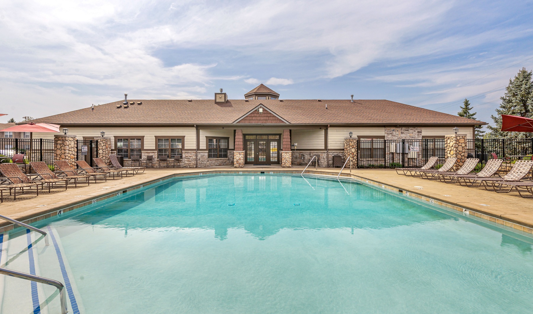 sparkling swimming pool facing an apartment complex clubhouse